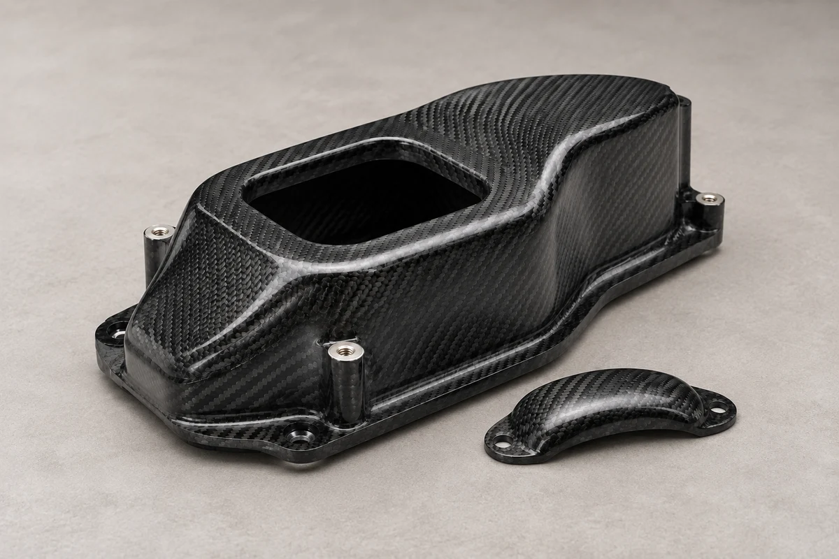 Illustrative molded carbon fiber housing with curved walls, mounting flange and metal inserts